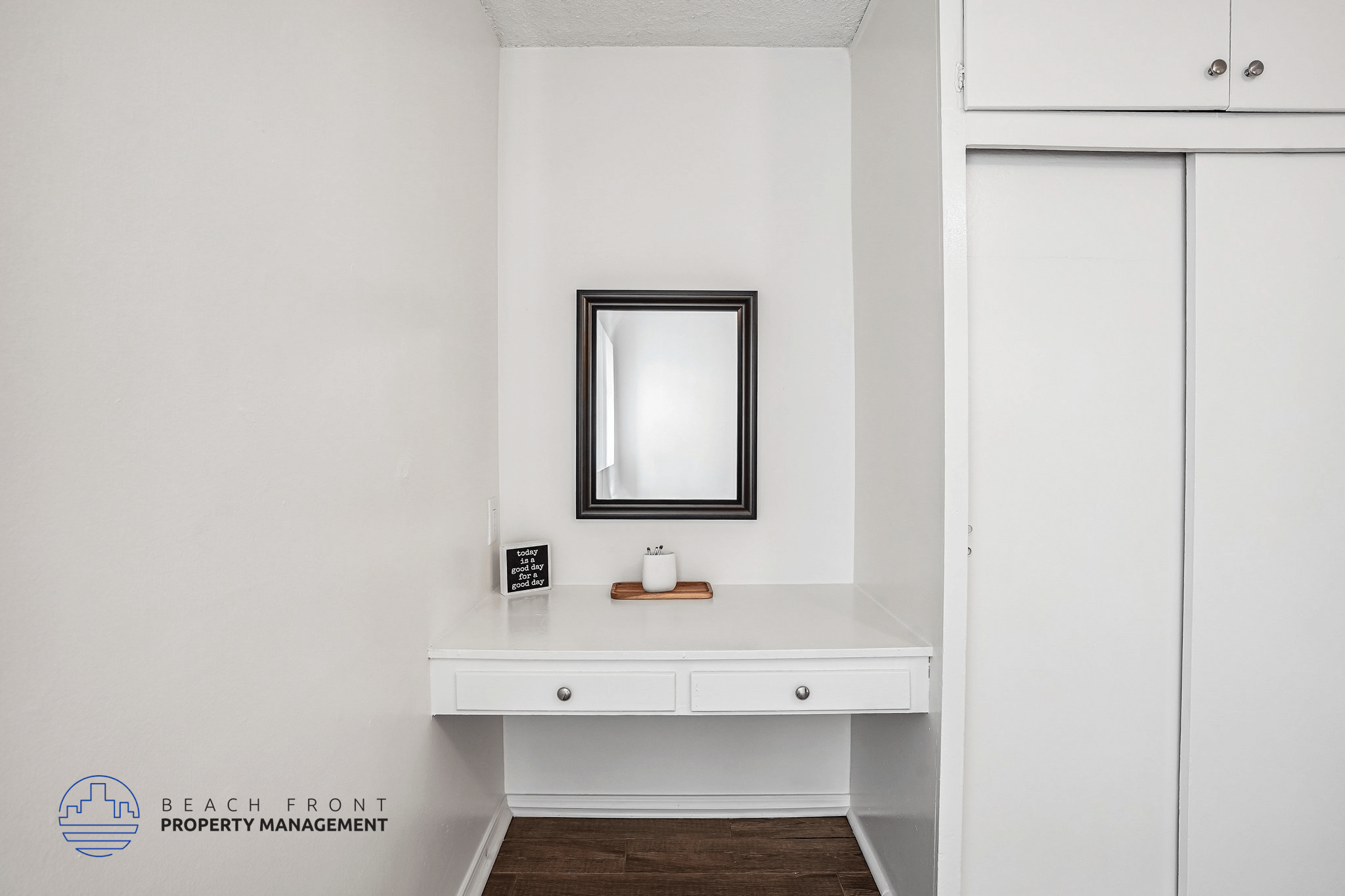 A white bathroom vanity with a mirror and a small shelf.